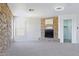 Spacious living room featuring a striking stone fireplace, plush carpet, and large windows for plenty of natural light at 23214 N 106Th Ave, Peoria, AZ 85383