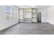 Bright, open living room with modern gray floors and a custom stone accent wall with built-in shelves and entertainment center at 23214 N 106Th Ave, Peoria, AZ 85383