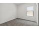 Bare bedroom with neutral gray carpet and a window, offering a blank canvas for customization at 23419 W Albeniz Pl, Buckeye, AZ 85326