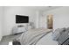 Modern bedroom featuring a flat-screen TV, stylish storage, and an en-suite bathroom for added convenience at 23419 W Albeniz Pl, Buckeye, AZ 85326