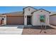 Attractive home with a two-car garage, desert landscaping, and a young tree at 23419 W Albeniz Pl, Buckeye, AZ 85326