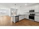Bright, modern kitchen with white cabinets, stainless steel appliances, and hardwood floors at 23419 W Albeniz Pl, Buckeye, AZ 85326
