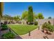 Lush backyard with green grass, garden, patio, and hot tub at 2440 W Arroyo Way, San Tan Valley, AZ 85144