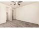 Clean, vacant bedroom with ceiling fan, grey carpet and ensuite bathroom at 2440 W Arroyo Way, San Tan Valley, AZ 85144