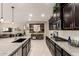 Open-concept kitchen with a large island, granite countertops, dark cabinets, and an adjacent living space at 2440 W Arroyo Way, San Tan Valley, AZ 85144