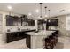 Modern kitchen featuring dark wood cabinets, granite countertops, and a central island with bar stool seating at 2440 W Arroyo Way, San Tan Valley, AZ 85144