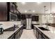 Well-equipped kitchen with stainless steel appliances, granite counters, dark wood cabinets, and a gas cooktop at 2440 W Arroyo Way, San Tan Valley, AZ 85144