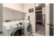 Laundry room with front loading washer and dryer, shelves, and access to closet at 2440 W Arroyo Way, San Tan Valley, AZ 85144