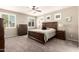 Serene bedroom with a wooden bed frame, neutral walls, a ceiling fan, and large windows at 2440 W Arroyo Way, San Tan Valley, AZ 85144