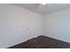 Minimalist bedroom featuring dark wood floors, two doors, and light neutral walls at 30944 N Bramwell Ave, San Tan Valley, AZ 85143