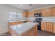 The kitchen features a center island, light wood cabinetry, and modern appliances at 30944 N Bramwell Ave, San Tan Valley, AZ 85143