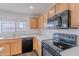Modern kitchen featuring light wood cabinets, dark appliances, and quartz countertops at 30944 N Bramwell Ave, San Tan Valley, AZ 85143