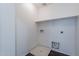 A utilitarian laundry room with white walls, overhead shelving, and hookups at 30944 N Bramwell Ave, San Tan Valley, AZ 85143