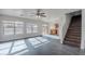 Bright living room with wood floors, ceiling fan, backyard view, and staircase access to second floor at 30944 N Bramwell Ave, San Tan Valley, AZ 85143