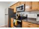 Kitchen with stainless appliances, tile flooring, wood cabinets and drawers at 3314 N 68Th St # 129, Scottsdale, AZ 85251