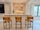 Stylish bar area features sleek countertops, seating, and illuminated shelving for liquor and glassware at 3669 E Boot Track Trl, Gilbert, AZ 85296