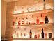Stylish bar area with lighted shelves displaying an array of liquor bottles at 3669 E Boot Track Trl, Gilbert, AZ 85296