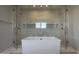 Luxurious bathroom with a soaking tub nestled between and marble showers with glass doors and overhead rain shower heads at 3669 E Boot Track Trl, Gilbert, AZ 85296