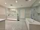 Bright bathroom with double vanity, bathtub, glass-enclosed shower, and patterned floor at 3669 E Boot Track Trl, Gilbert, AZ 85296