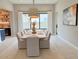 Bright dining room features a long wooden table, white chairs, stylish lighting, and decor at 3669 E Boot Track Trl, Gilbert, AZ 85296