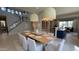 Open-concept dining room featuring an expansive table beneath modern pendant lights and a wine rack at 3669 E Boot Track Trl, Gilbert, AZ 85296