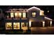 Striking two-story home exterior featuring well-manicured lawn and a welcoming facade lit with decorative lights at 3669 E Boot Track Trl, Gilbert, AZ 85296