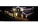 Nighttime aerial shot showcasing the home's striking architectural details and inviting exterior lighting at 3669 E Boot Track Trl, Gilbert, AZ 85296
