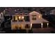 Nighttime aerial shot showcasing the home's striking architectural details and inviting exterior lighting at 3669 E Boot Track Trl, Gilbert, AZ 85296