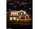 Nighttime aerial shot showcasing the home's striking architectural details and inviting exterior lighting at 3669 E Boot Track Trl, Gilbert, AZ 85296