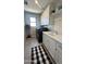 Bright laundry room features white shaker cabinets, quartz countertop, subway tile backsplash and a checkered rug at 3669 E Boot Track Trl, Gilbert, AZ 85296