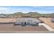 Wide aerial view of a modern home with neutral desert landscaping and mountain views in the distance at 3933 E Freeman Ln, San Tan Valley, AZ 85140