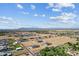 Scenic aerial view of homes in a neighborhood with desert and mountain range in the distance at 3933 E Freeman Ln, San Tan Valley, AZ 85140