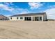 Wide angle view of the home's rear showcasing the modern style, windows, and spacious dirt backyard at 3933 E Freeman Ln, San Tan Valley, AZ 85140