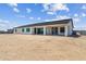 Rear view showcasing the home's design with large windows, a covered patio, and expansive yard ready for customization at 3933 E Freeman Ln, San Tan Valley, AZ 85140