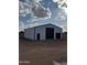 Exterior view of white and black barn with matching garage doors and standard entrance door at 3933 E Freeman Ln, San Tan Valley, AZ 85140