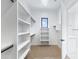 Large closet with built-in shelving, bars for hanging clothes, and natural light coming from the window at 3933 E Freeman Ln, San Tan Valley, AZ 85140