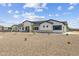 A contemporary one-story home with a gravel yard, green grass and desert plants provides low maintenance landscaping at 3933 E Freeman Ln, San Tan Valley, AZ 85140