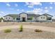 A well-manicured front yard with a circular driveway leads up to a modern home with a stone base and white siding at 3933 E Freeman Ln, San Tan Valley, AZ 85140