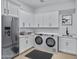 Well-organized laundry room with modern washer/dryer, stainless steel fridge, and ample cabinet space at 3933 E Freeman Ln, San Tan Valley, AZ 85140