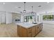 Open-concept living space featuring a kitchen island, fireplace, and sliding glass doors to the backyard at 3933 E Freeman Ln, San Tan Valley, AZ 85140
