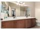 Large bathroom showcasing double sinks, wood cabinets, and a spacious mirror at 4061 E Torrey Pines Ln, Chandler, AZ 85249