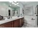Bright bathroom with double sinks, a large mirror, and a soaking tub at 4061 E Torrey Pines Ln, Chandler, AZ 85249