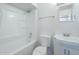 Well-lit bathroom features a sink and vanity, toilet, and shower-tub combination with white tiles at 4209 N 48Th Dr, Phoenix, AZ 85031