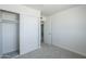 Well-lit bedroom with grey carpet floors, closet and a door leading to another room at 4209 N 48Th Dr, Phoenix, AZ 85031