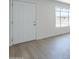 Bright entryway featuring a white door, brick accent wall, and luxury vinyl plank flooring at 4209 N 48Th Dr, Phoenix, AZ 85031