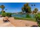 Picturesque community pond with a fountain, seating, and manicured landscaping at 45 Leisure World -- # 45, Mesa, AZ 85206