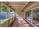Covered patio with brick flooring, screened windows, and sliding door access to the backyard at 5038 N 20Th Ave, Phoenix, AZ 85015