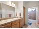 Bathroom featuring tile countertop with wood cabinets and door to shower at 5221 N Tuthill Rd, Litchfield Park, AZ 85340