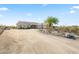 A sprawling home with desert landscaping, a circular driveway, and a charming desert tree at 5221 N Tuthill Rd, Litchfield Park, AZ 85340