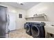 Efficient laundry room with stainless steel refrigerator and modern machines at 5221 N Tuthill Rd, Litchfield Park, AZ 85340